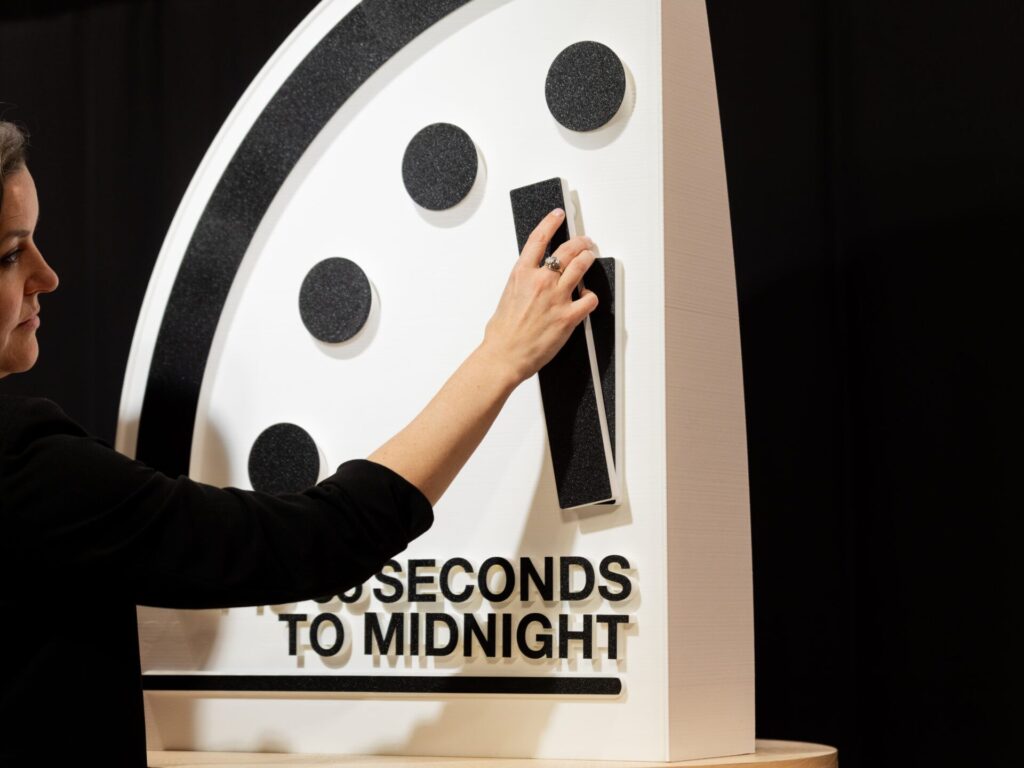 Bulletin President and CEO Alexandra Bell moves the minute hand on the Doomsday Clock. (Image by Jamie Christiani)