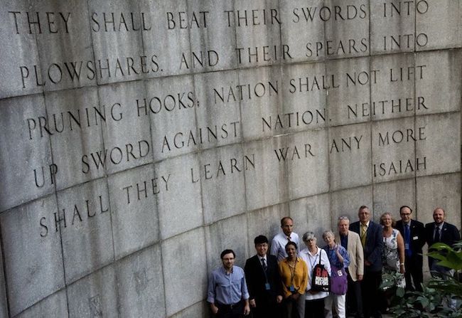 Photo: Faith groups' representatives in front of the Isaiah Wall across the street from the United Nations Building in New York City with the Bible verse 